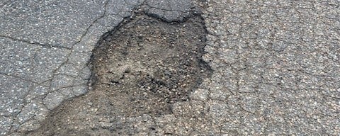 pothole in gray asphalt road