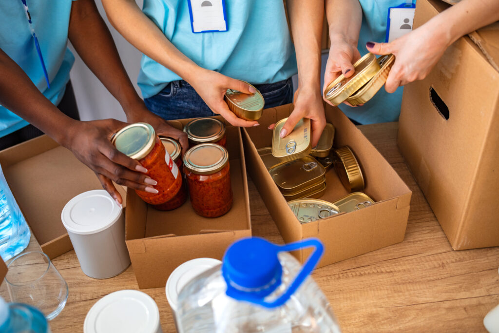 Hands pack boxes for food pantry services