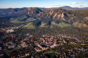 aerial view of Boulder Colorado with Flatirons mountains blue sky and CU Boulder campus