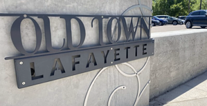 black metal sign Old Town Lafayette on gray stone