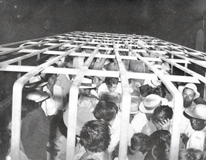 Historic black and white photo of Mexicans and Mexican-Americans in a caged truck during mass deportation of Operation Wetback in the U.S. 1930s