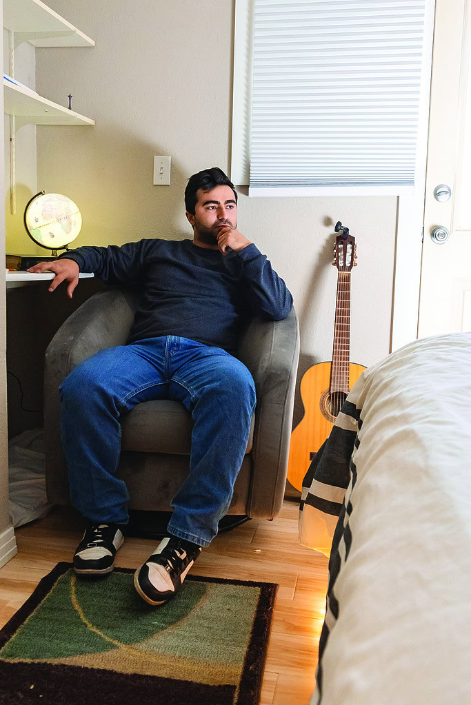 Rohan Mesto Syrian refugee in bedroom with guitar and globe in Lafayette Colorado