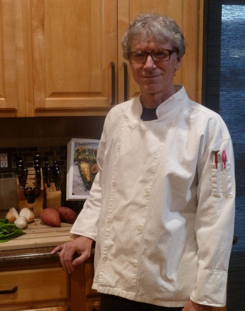 Dr. Glenn Lopate in a chef's coat founder of The Doctor's Cuisine in Longmont, Colorado